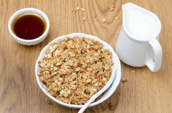 Zelfgemaakte muesli, kruik van melk en een kom van honing voor ontbijt — Stockfoto