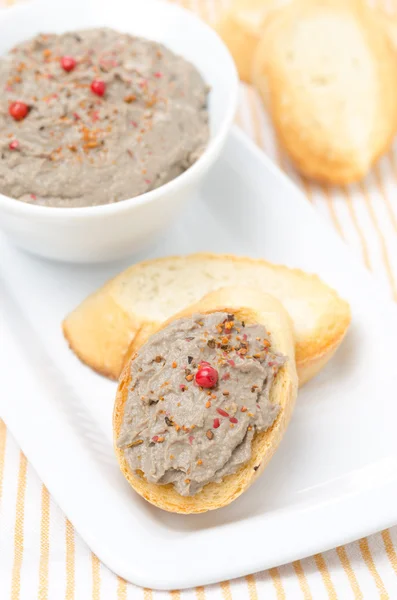 Liver pate with pink pepper on toasted bread on a plate — Stock Photo, Image