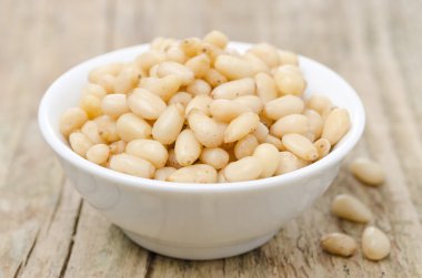 ahşap zemin üzerinde bir kasede çam fıstığı