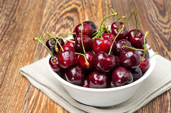 Bowl of fresh cherries on a wooden background — Stock Photo, Image