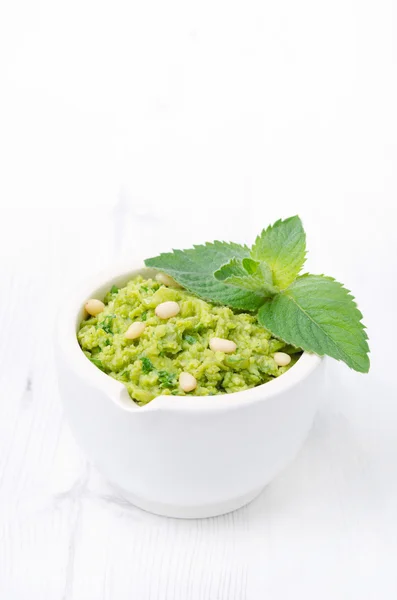 Nahaufnahme von grünem Erbsenpesto mit Minze auf weißem Hintergrund — Stockfoto