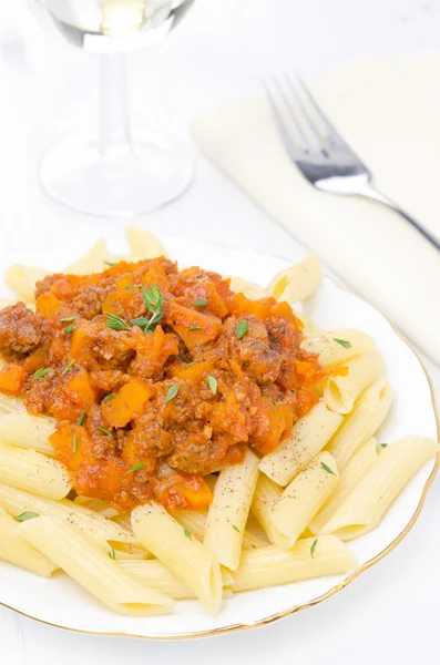 Pasta di penne con sugo di manzo, pomodoro e zucca su un piatto — Foto Stock