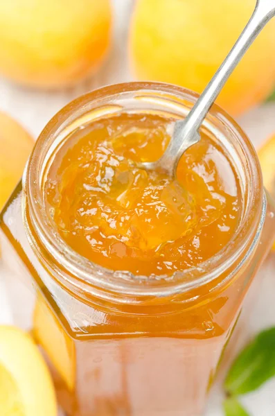 Apricot marmalade in a spoon close-up, vertical — Stock Photo, Image