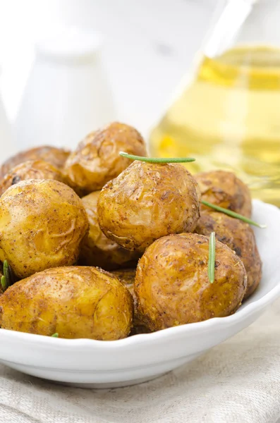 Baked new potatoes with spices and rosemary in a bowl, vertical — Stock Photo, Image