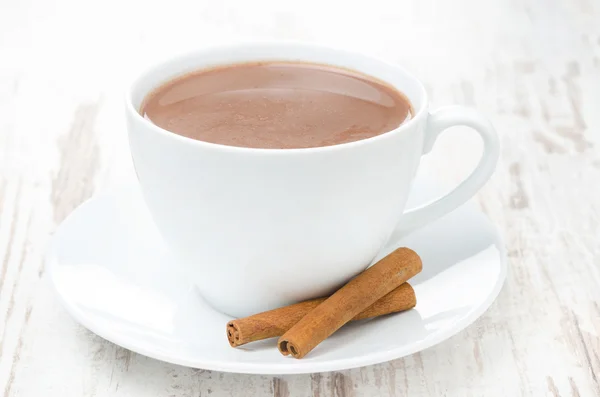Šálek kakaa se skořicí na bílém stole, horizontální — Stock fotografie