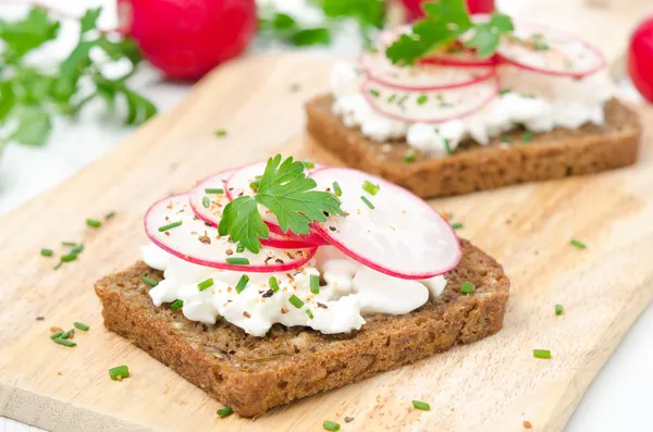 Grain bread with soft cheese, radish and chives — Stockfoto