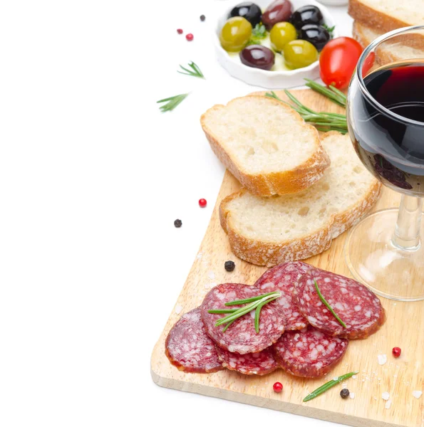 Salami, bread, olives and glass of wine on a wooden board — Stock Photo, Image