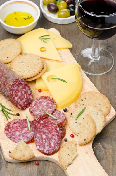 Salami, fromage, biscuits, olives et un verre de vin — Photo