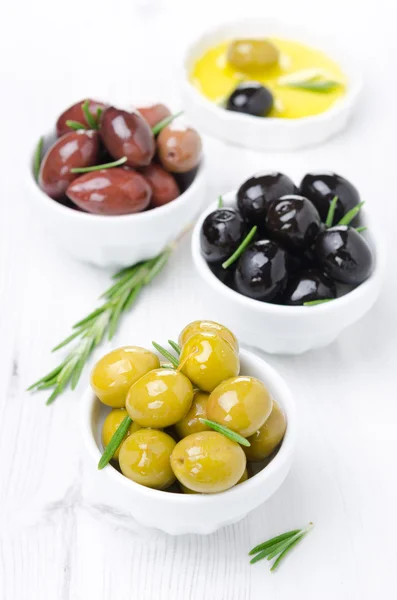 Tre sorters oliver, färsk rosmarin och olivolja — Stockfoto