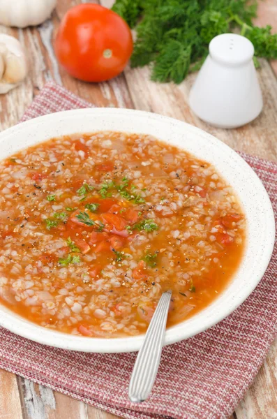 Tomatensuppe mit Buchweizengrütze in einem Teller senkrecht — Stockfoto