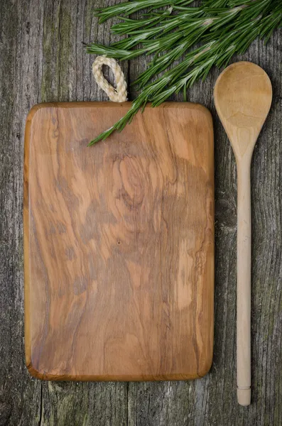 Vintage cutting board with space for text, spoon and rosemary — Stock Photo, Image