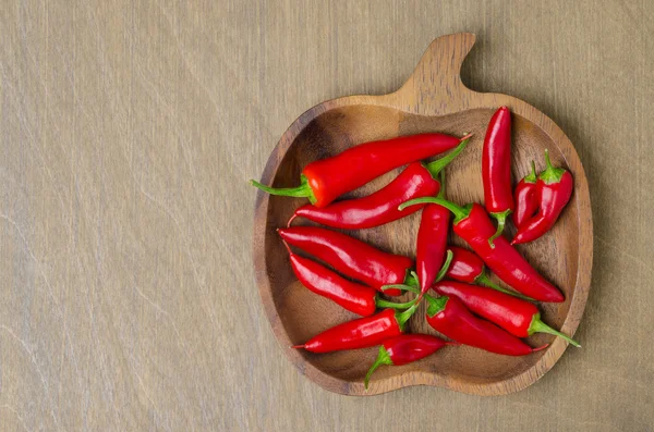 Houten schaal met rode chilipepertjes (en ruimte voor tekst) — Stockfoto