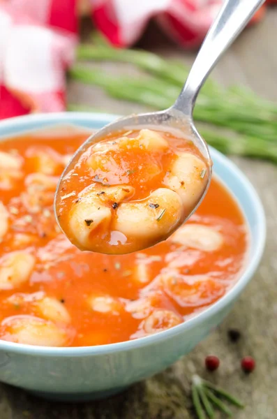 Tomato soup with pasta, white beans and rosemary in a spoon — Stock Photo, Image