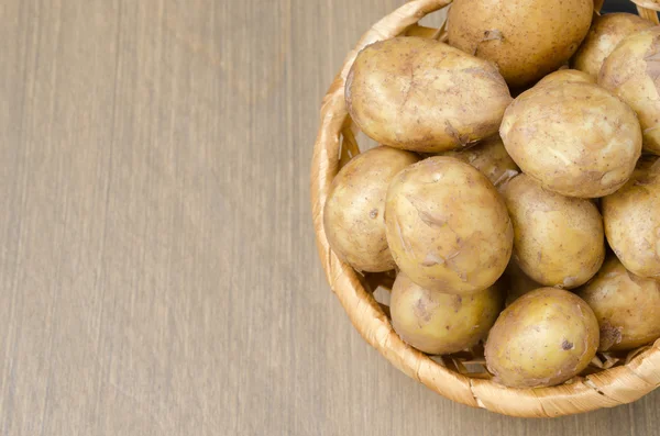 Bovenaanzicht van krielaardappelen in een mand op een grijze houten achtergrond — Stockfoto