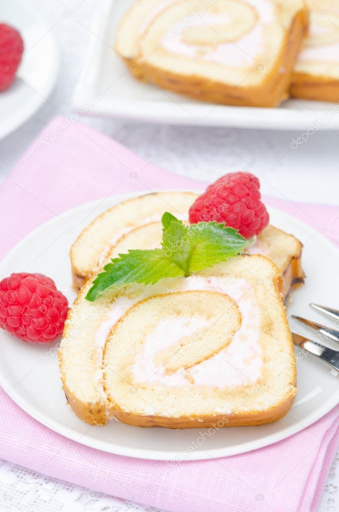 piece of swiss roll with raspberry cream on the plate, vertical
