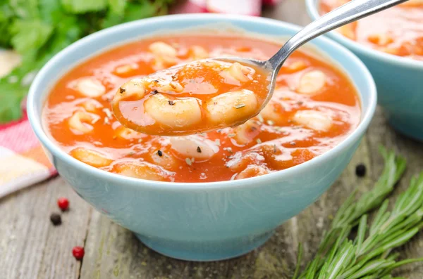 Cuillère de soupe aux tomates avec des pâtes, des haricots blancs et du romarin — Photo