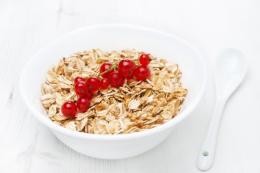 kase müsli ve beyaz bir tablo üzerinde kırmızı kuş üzümü