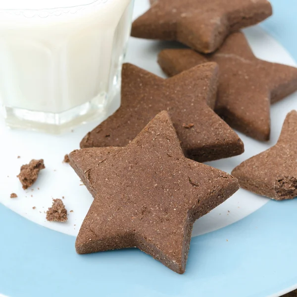 Chocolate chip cookies in the form of stars on a plate and milk — Stock Photo, Image