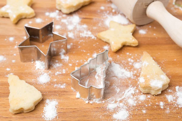 Weihnachtsplätzchen und Backform auf einem Holzbrett — Stockfoto