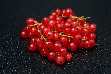 siyah bir arka plan üzerinde kırmızı kuş üzümü