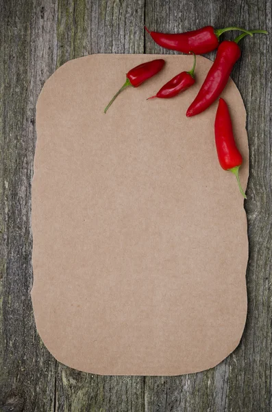 Papier voor recept en chilipepers op oude houten achtergrond — Stockfoto