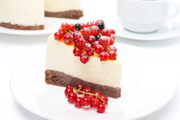 Piece of cheesecake with red and black currants and coffee — Stock Photo, Image