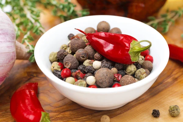 Assorted hot peppers in a bowl and fresh chili peppers, close-up — Stock Photo, Image