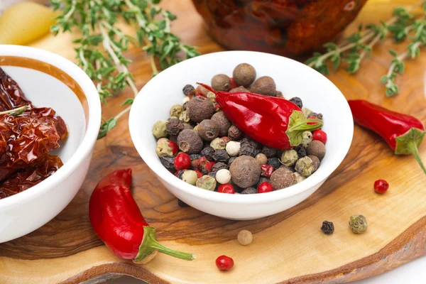 Assorted hot peppers in a bowl and fresh chili peppers — Stock Photo, Image