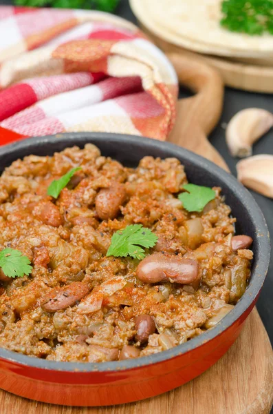 Chili con carne in a cast iron skillet vertical closeup — Stock Photo, Image