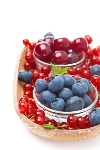 Fresh blueberries, cherries and red currants in a wooden bowl — Stock Photo, Image
