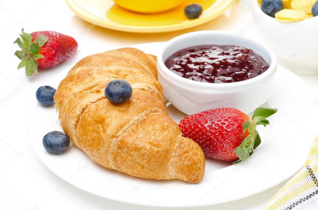 Breakfast with croissant, jam, fresh berries and coffee