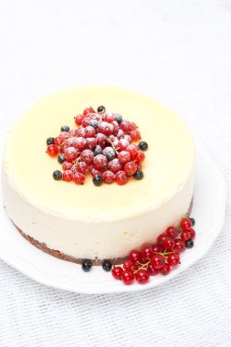 Cheesecake dikey kırmızı ve siyah kuşüzümü ile dekore edilmiştir.