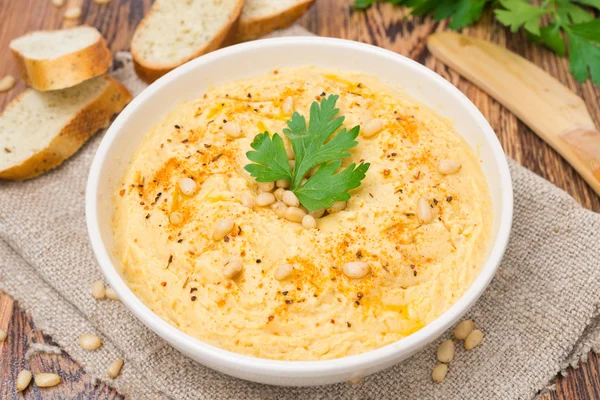Hummus with pine nuts in a bowl, horizontal — Stock Photo, Image