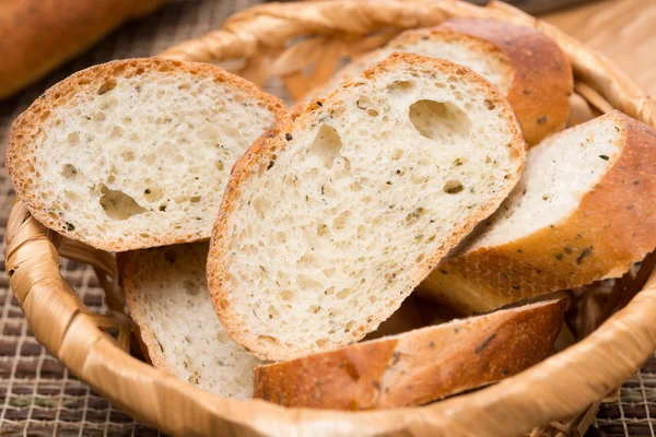 Pezzi di baguette con erbe in un cestino, primo piano — Foto Stock