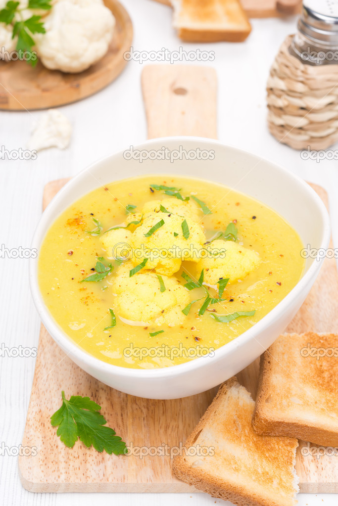 cauliflower soup with curry in a bowl and toast