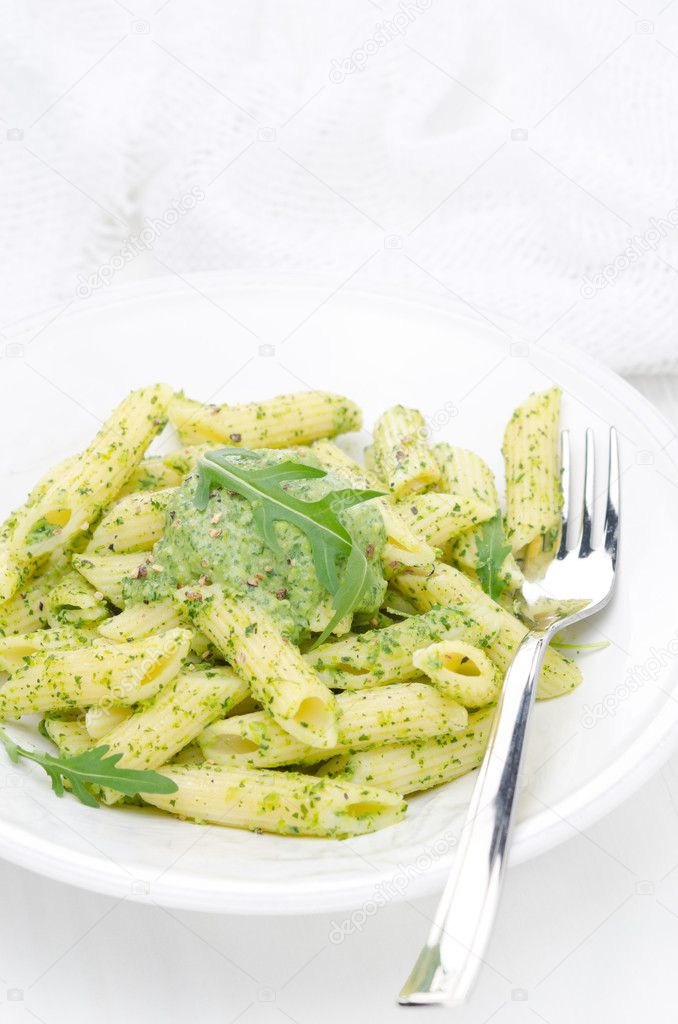 pasta penne with sauce of arugula and peas vertical