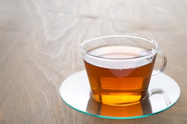 şeffaf cam ahşap arka plan üzerinde siyah çay fincan