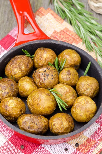 Pommes de terre nouvelles cuites au four avec romarin dans une poêle, vue sur le dessus — Photo