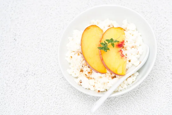 Cottage cheese with honey, nuts, fresh peaches and thyme — Stock Photo, Image