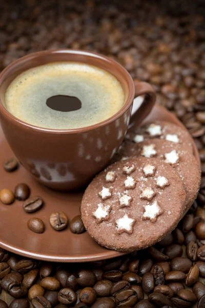 Cup of black coffee and Christmas cookies on the coffee beans — Stock Photo, Image