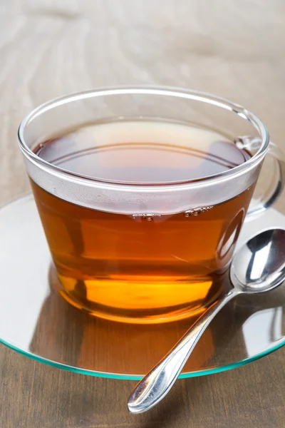 Glas kopp svart te på trä bakgrund, närbild — Stockfoto