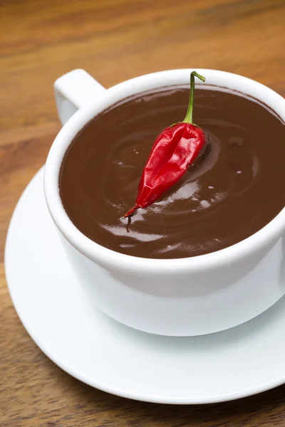 Cioccolata calda con peperoncini su fondo di legno — Foto Stock