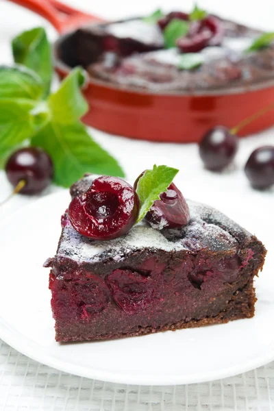 Piece of chocolate Clafoutis with cherries and powdered sugar — Stock Photo, Image