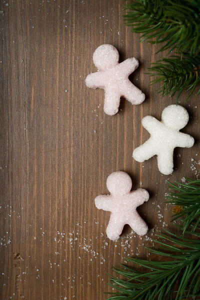 Vánoční dřevěné pozadí s cukru málo mužů a jedle větev — Stock fotografie