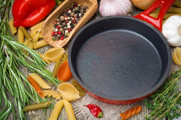 空的油炸锅、 蔬菜和香料木制背景上 — 图库照片