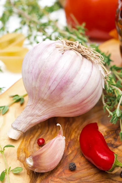 Fresh garlic, thyme and chili peppers on a wooden board, closeup — Stock Photo, Image