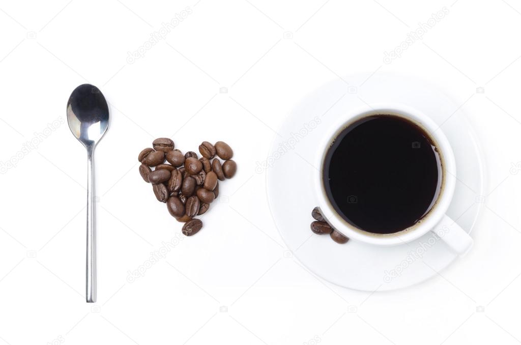 spoon, cup of black coffee and coffee beans in the form of heart