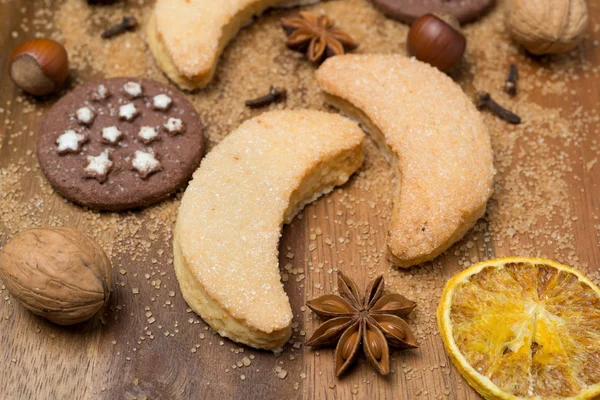 Biscoitos de Natal, especiarias e nozes em um fundo de madeira — Fotografia de Stock