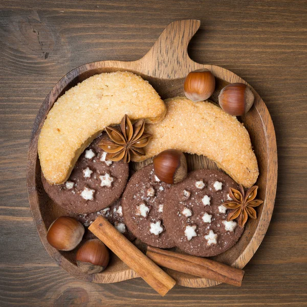 Cukroví, koření a ořechy na dřevěné desce — Stock fotografie