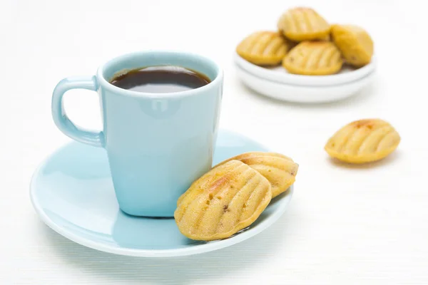 Galletas de Madeleine y una taza de café sobre un fondo blanco —  Fotos de Stock